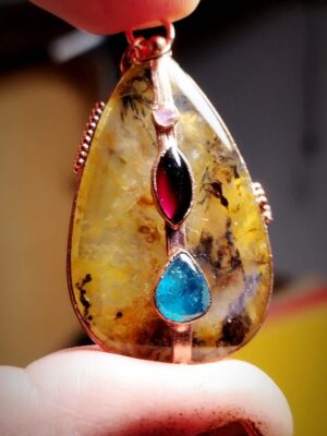 detail ručně vyráběného přívěsku z minerálů Srdce země s barevnými kameny