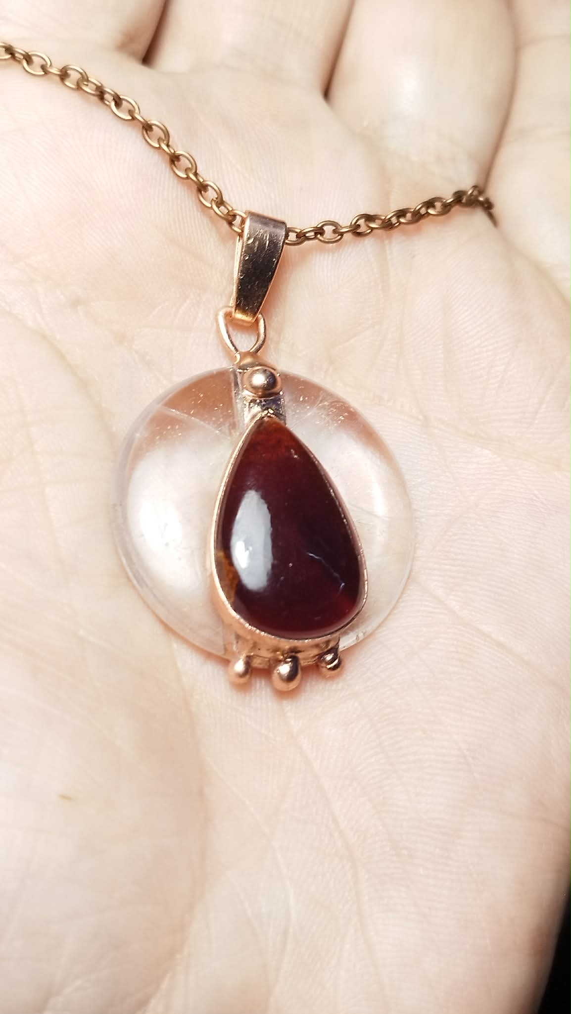 Měděný talisman Kapka životního světla s křišťálem a granátem na dlani, autorský šperk Sirius