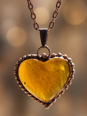 Detail jantarového srdce ze Sumatry v měděném rámu, autorský talisman Sirius