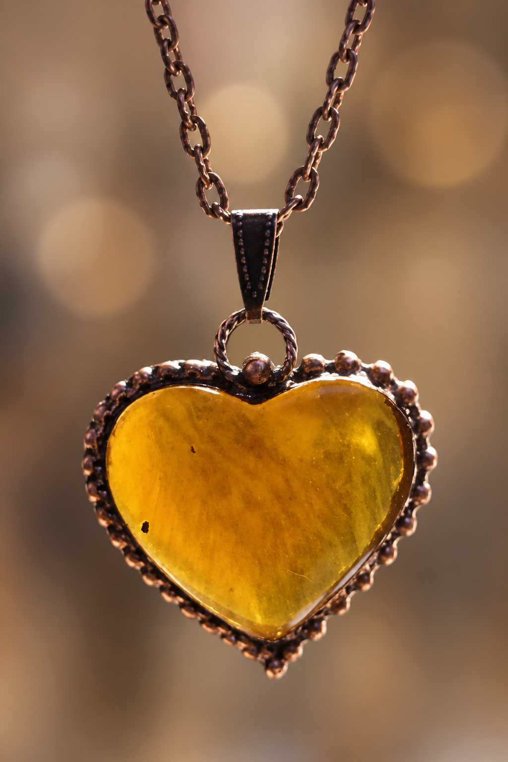 Detail jantarového srdce ze Sumatry v měděném rámu, autorský talisman Sirius