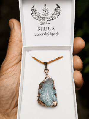 Surový akvamarín zasazený do mědi jako ručně vyrobený talisman Sirius na dlani autora