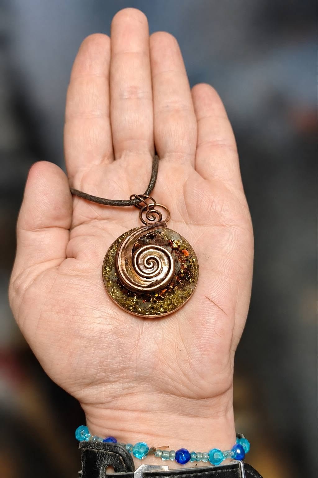 Orgonitový talisman Podzimní souznění s citrínem, jahodovým křemenem, křišťálem a měděnou spirálou na lidské dlani
