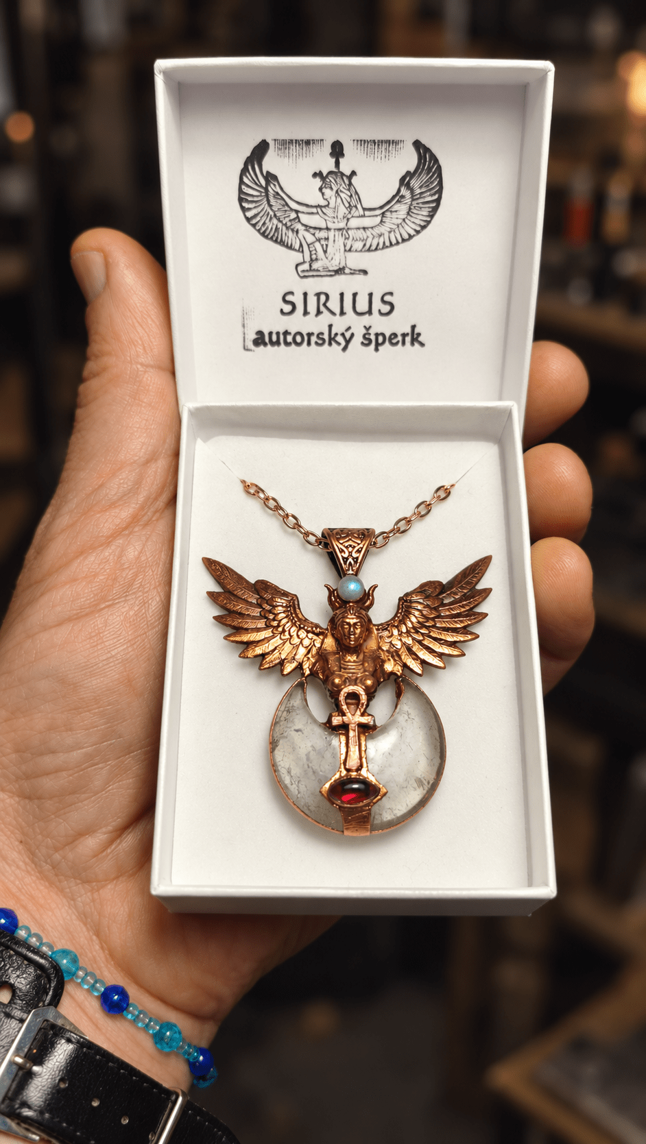 Měděný talisman Křídla Isis s granátem, měsíčním kamenem, křišťálovým měsícem a symbolem anch v krabičce Sirius autorský šperk